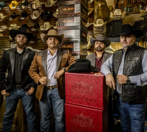 El Alazán team in cowboy hats with red Stetson hat cases